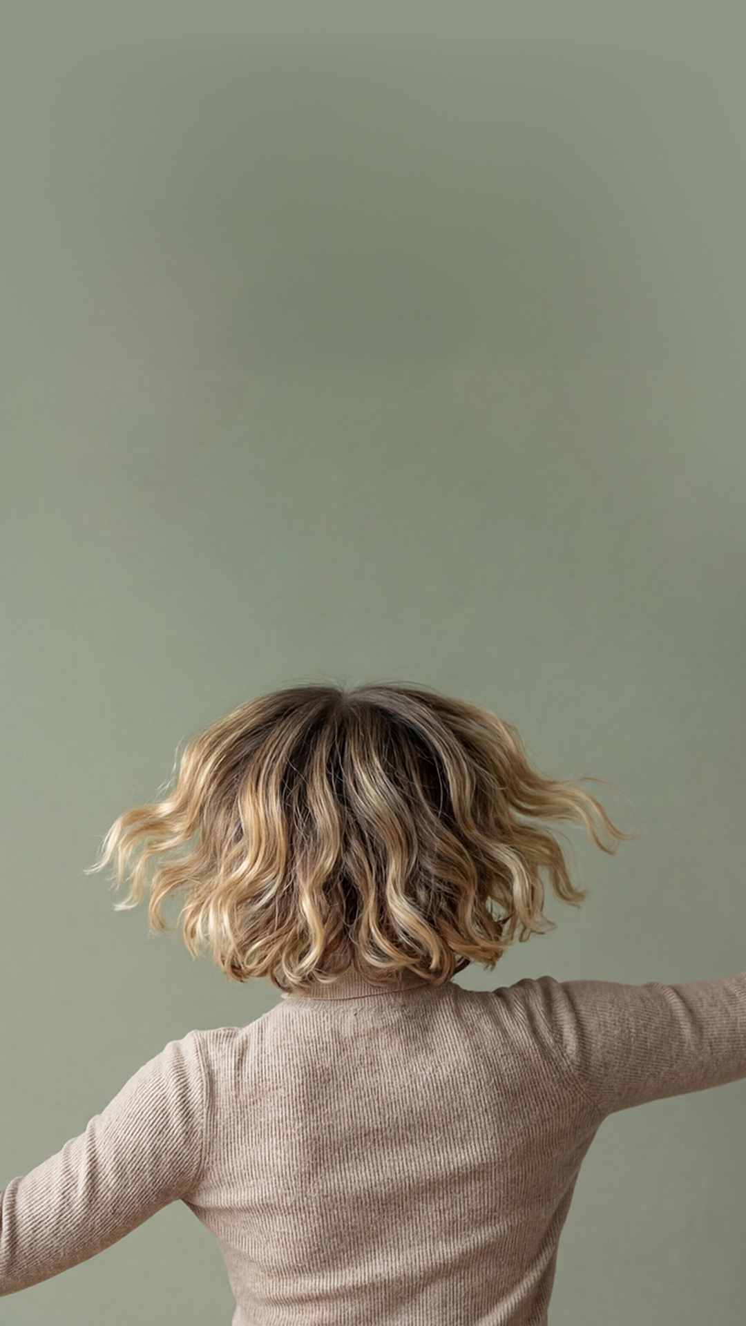 Headerbild zeigt eine Frau, die beide Arme in die Höhe hebt, während ihre voluminösen Haare schwungvoll fallen – Friseurin Lanzingen